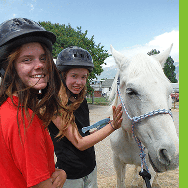 Female Aspiro students petting a horse
