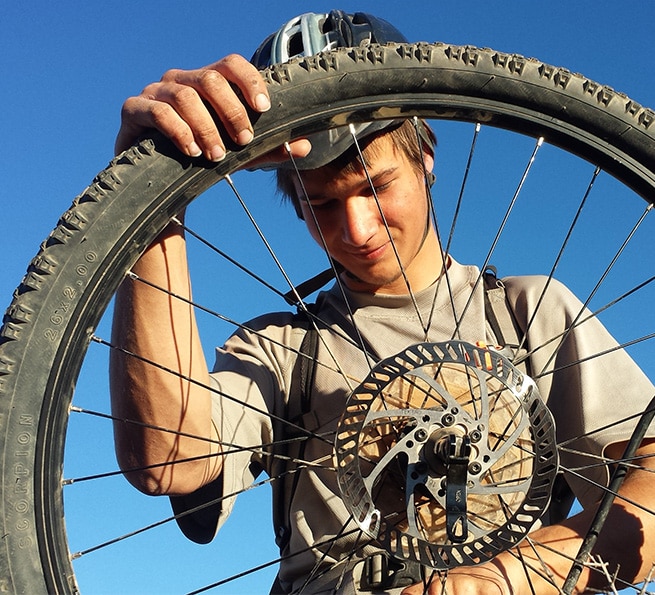 Aspiro student inspecting bicycle wheel